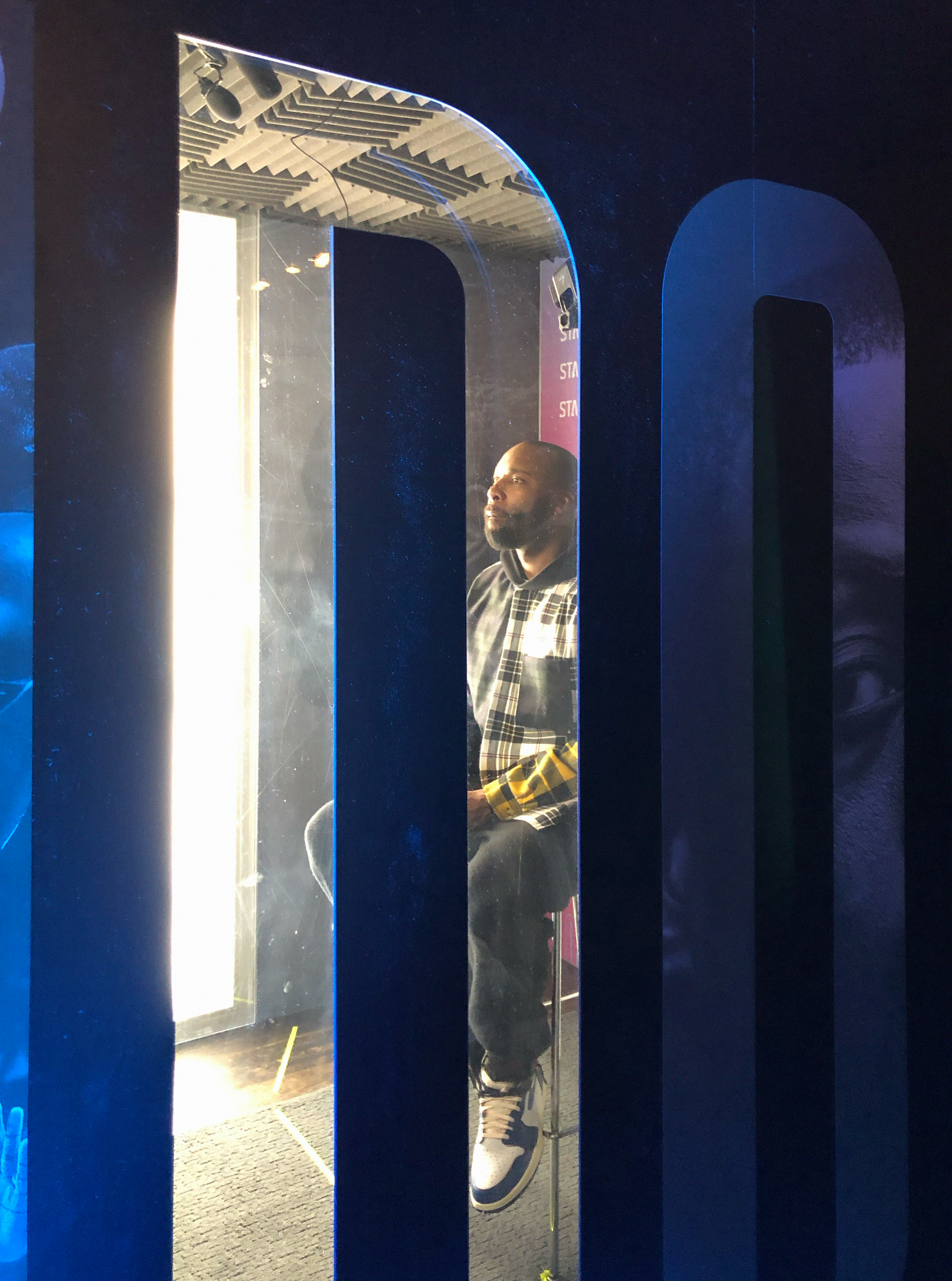 An athlete seated inside the soundproof booth, seen through the door cutout